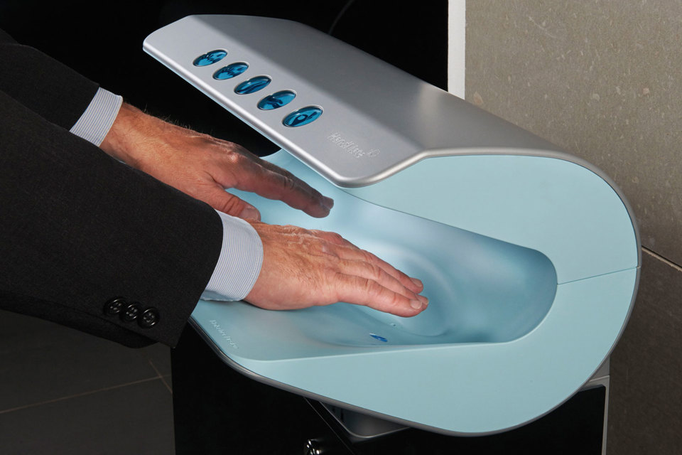 To hænder i et apparat til at lufttørre hænder